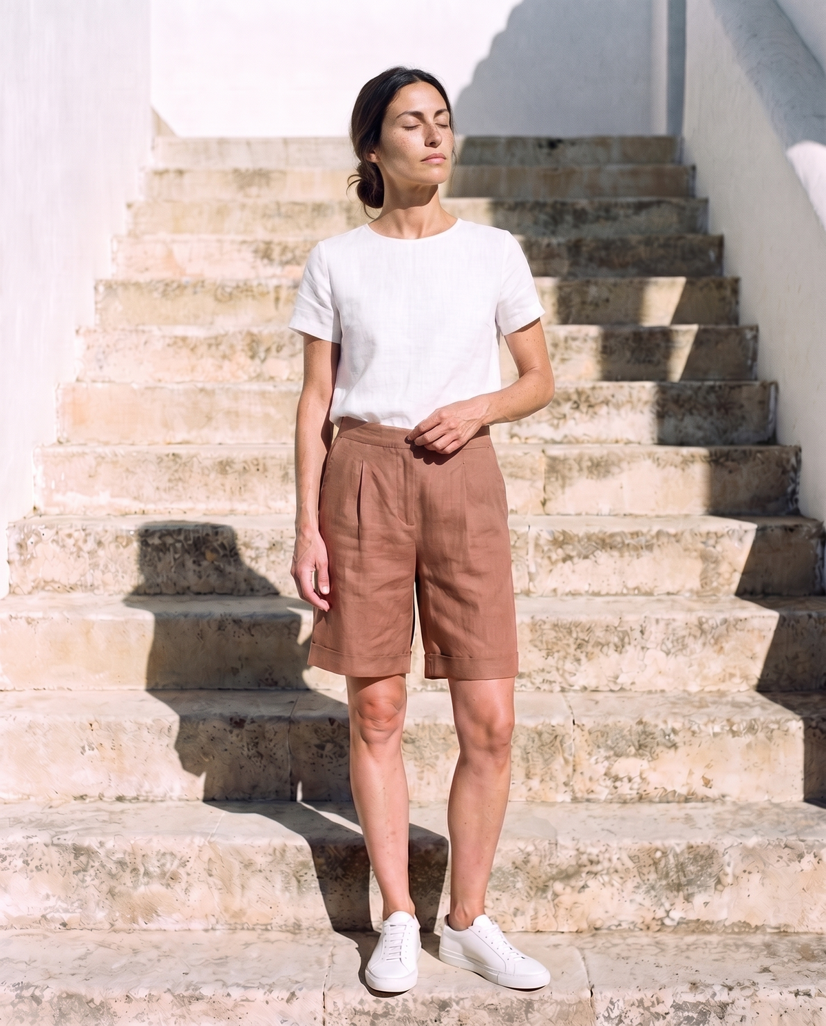 Rosa Shorts in clay, face tilted up to the sun