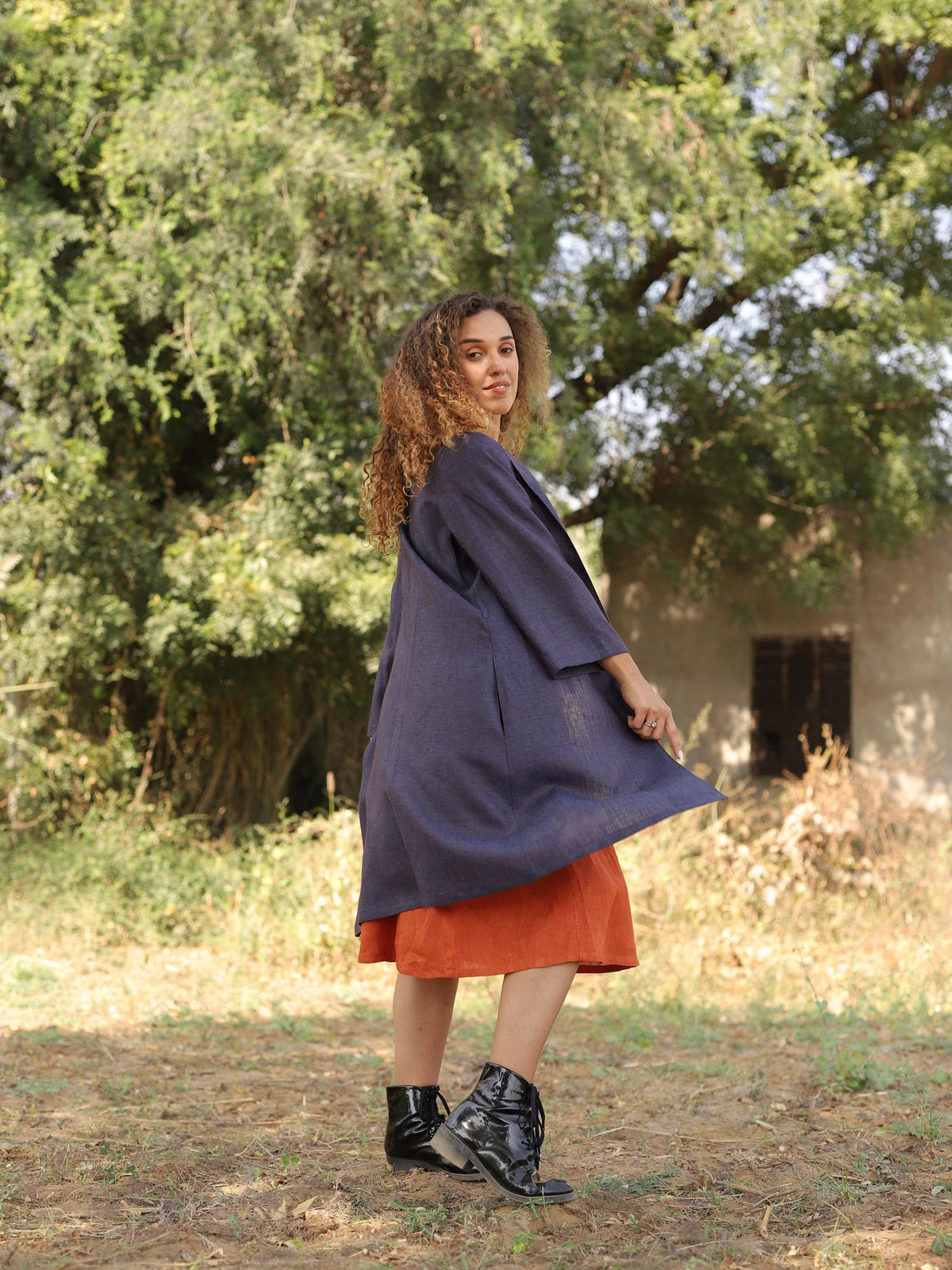 Long Linen Duster Coat in navy blue linen, turning, showing the swing