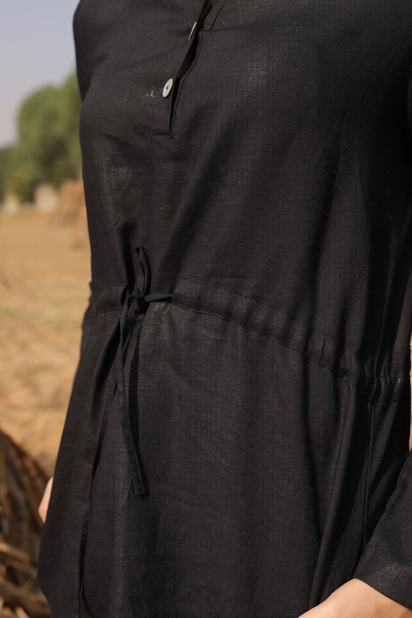 Black drawstring waist mini dress in washed linen, photographed in Jaipur