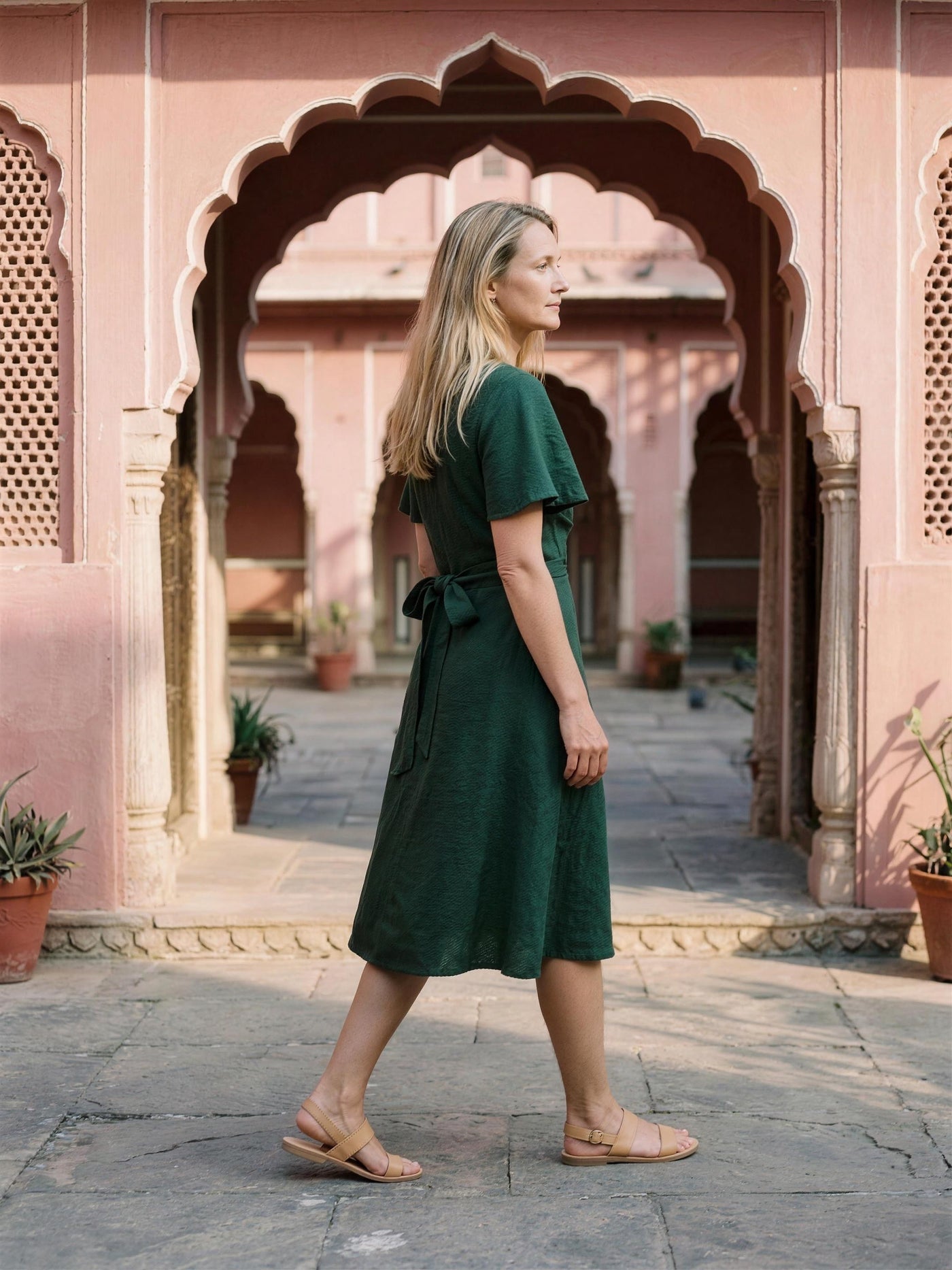 Bottle green linen wrap dress photographed in a Jaipur haveli courtyard