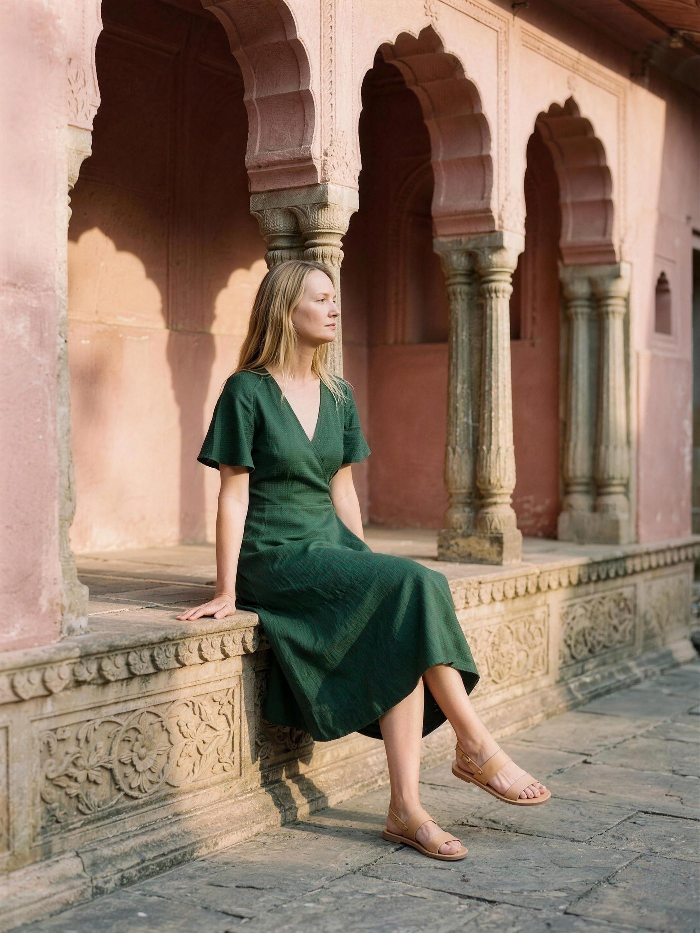 Bottle green linen wrap dress photographed in a Jaipur haveli courtyard