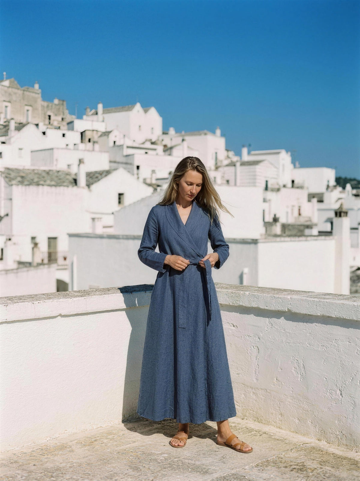 Indigo linen wrap maxi dress photographed on a whitewashed rooftop terrace