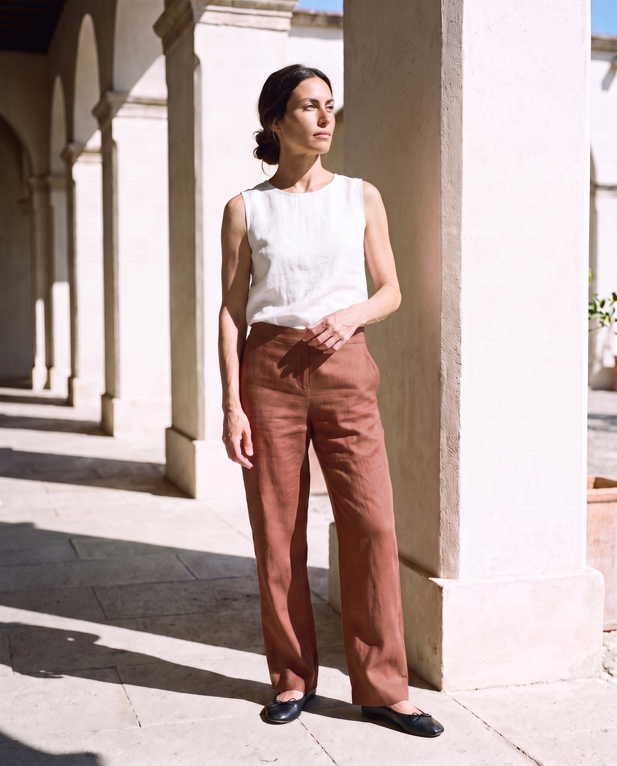 Nina Trousers in clay, face tilted up to the sun