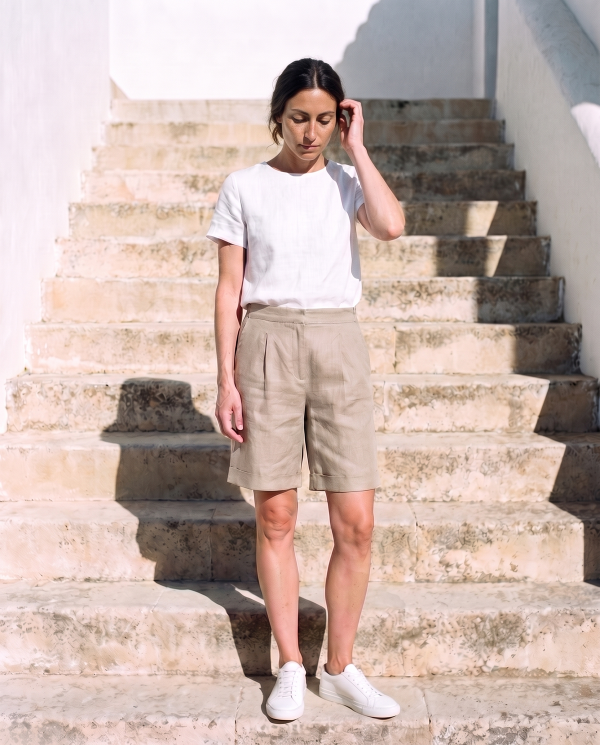 Rosa Shorts in natural, weight shifted, tucking her hair behind her ear